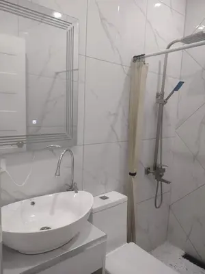a white bathroom with a sink and a shower at Bellas Apartment u1 in Manila