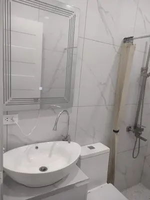 a white bathroom with a sink and a toilet at Bellas Apartment u1 in Manila