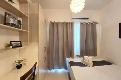 a room with a bed and a window with curtains at 1BR Condotel with Balcony at FAME Residences #FM13 in Manila