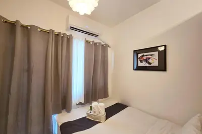 a bedroom with a window with curtains and a bed at 1BR Condotel with Balcony at FAME Residences #FM13 in Manila