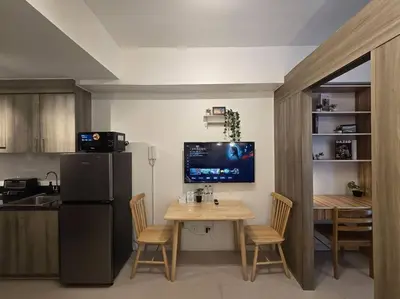 a kitchen with a table and a refrigerator and a table and chairs at 1BR Condotel with Balcony at FAME Residences #FM14 in Manila