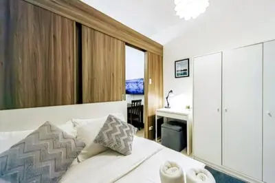 a bedroom with a bed with a desk and a bed sidx sidx sidx at 1BR Condotel with Balcony at FAME Residences #FM17 in Manila