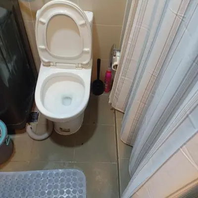 a bathroom with a toilet with the lid up at SMDC Coast Residences in Manila