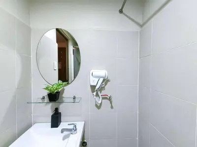 a white bathroom with a sink and a mirror at 1BR Condotel with Balcony at FAME Residences #FM25 in Manila