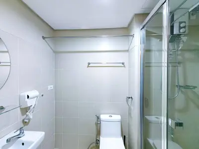 a bathroom with a toilet and a glass shower at 1BR Condotel with Balcony at FAME Residences #FM08 in Manila