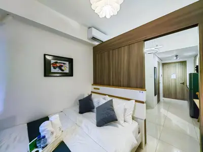a bedroom with a white couch and a table at 1BR Condotel with Balcony at FAME Residences #FM08 in Manila