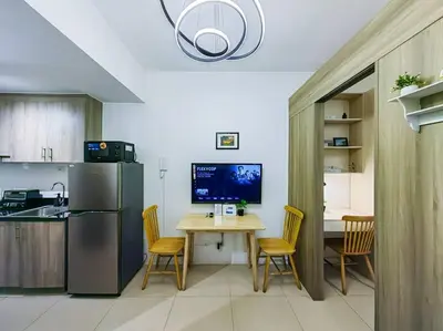 a kitchen with a table and a refrigerator at 1BR Condotel with Balcony at FAME Residences #FM08 in Manila