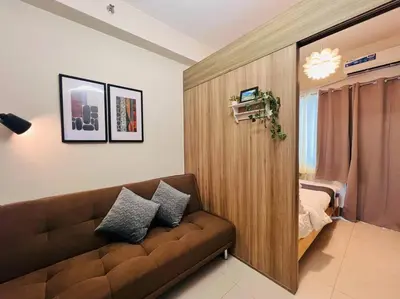 a living room with a couch and a bedroom at 1BR Condotel with Balcony at FAME Residences #FM27 in Manila