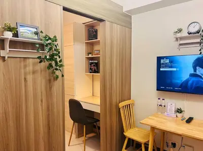 a room with a desk and a tv in a room at 1BR Condotel with Balcony at FAME Residences #FM27 in Manila