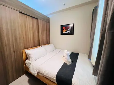 a small bedroom with a white bed with a window at 1BR Condotel with Balcony at FAME Residences #FM27 in Manila