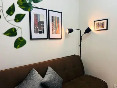 a living room with a couch and a lamp and pictures at 1BR Condotel with Balcony at FAME Residences #FM28 in Manila