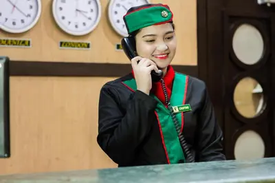 a woman in uniform talking on a cell phone at Eurotel Las Pinas in Manila