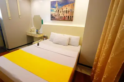 a room with a bed with a yellow and white at Eurotel Las Pinas in Manila