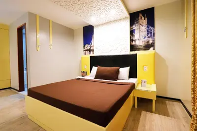 a bedroom with a bed with a yellow and white at Eurotel Las Pinas in Manila