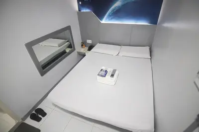 a small room with two beds and a mirror at Astrotel Calamba in Calamba