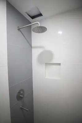 a bathroom with a shower with a light on the wall at Astrotel Calamba in Calamba