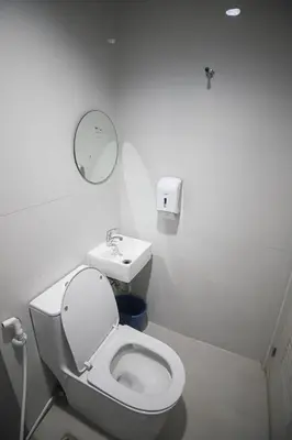 a white bathroom with a toilet and a sink at Astrotel Calamba in Calamba