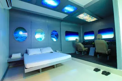 a bedroom with a bed and a room with windows at Astrotel Guadalupe in Manila