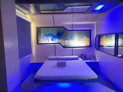 a room with two beds in a room with purple lights at Astrotel Guadalupe in Manila