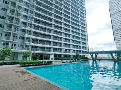 a large building with a swimming pool in front of a building at 1BR Condotel with Balcony at FAME Residences #FM32 in Manila