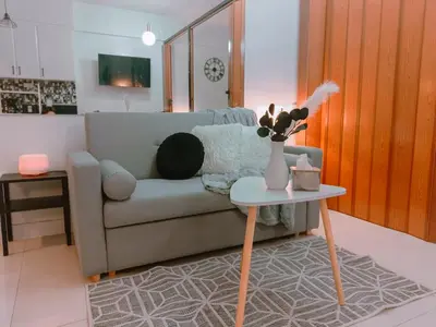 a living room with a couch and a table at Bright & Airy Studio near Venice Mall with Pool, Gym & Fast WiFi in Manila