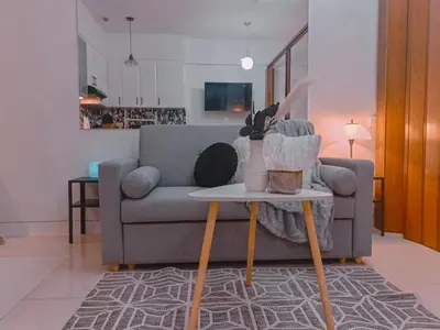 a living room with a couch and a table at Bright & Airy Studio near Venice Mall with Pool, Gym & Fast WiFi in Manila