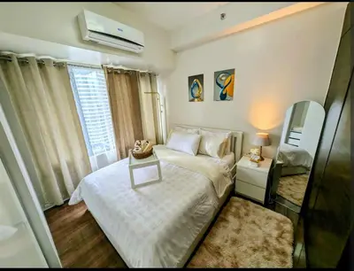 a small bedroom with a bed and a window at Sun and Moon cozywhite Air Residences Makati in Manila