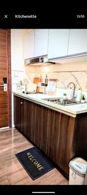 a kitchen with wooden cabinets and a sink at Sun and Moon cozywhite Air Residences Makati in Manila