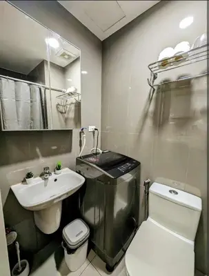 a bathroom with a toilet and a sink at Sun and Moon cozywhite Air Residences Makati in Manila