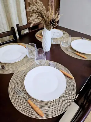 a table with white plates and utensils on it at Bubu and son suites staycation beside enchanted kingdom in Santa Rosa