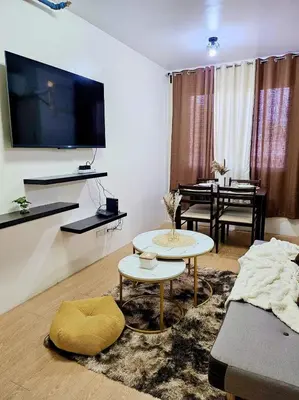 a living room with a couch and a table at Bubu and son suites staycation beside enchanted kingdom in Santa Rosa