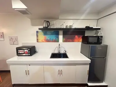 a small kitchen with a sink and a refrigerator at Makati Medical City Accommodation in Manila