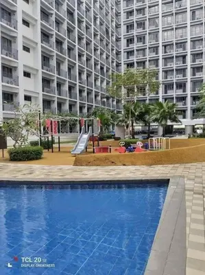 a swimming pool with a playground in front of a large building at JoVis Place Staycation near MOA(Wifi & Netflix) in Manila