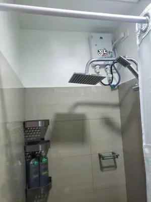 a bathroom with a sink and a shelf on the wall at JoVis Place Staycation near MOA(Wifi & Netflix) in Manila
