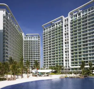two tall buildings with palm trees in front of them at Azure Urban Resort Residences in Manila