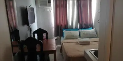 a small room with a bed and a table and chairs at Urban Deca Tower OYO 2 in Manila