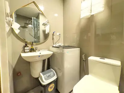 a bathroom with a sink and a toilet and a mirror at 1BR Makati, Air Residences M002 in Manila