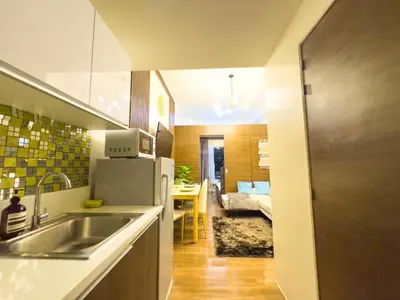 a kitchen with a sink and a refrigerator in a room at 1BR Makati, Air Residences M002 in Manila