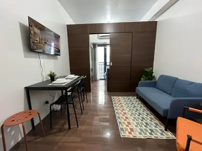 a living room with a blue couch and a table at Air Residence-Sunset & City Views Await in Manila