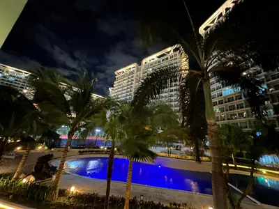 a group of palm trees and buildings at night at Azure Paranaque near Airport in Manila