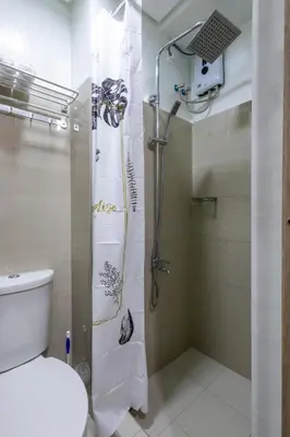 a bathroom with a shower and a toilet in it at Oasis Urban Stay 2 in Manila