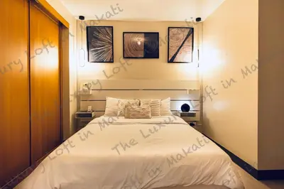 a bedroom with a bed with writing on the sheets at Cozy Loft in Makati in Manila
