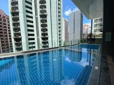 a large swimming pool in a city with tall buildings at Cozy Loft in Makati in Manila