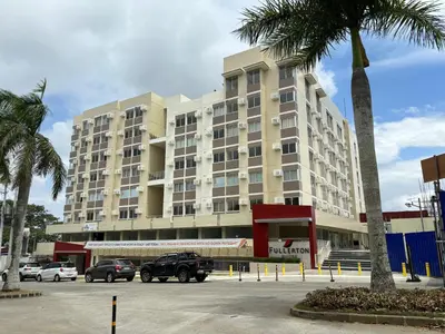 a large building with cars parked in a parking lot at Condo in silang - near nuvali and tagaytay in Silang
