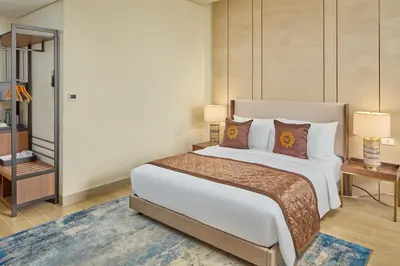 a bedroom with a large white bed with pillows at Grand Westside Manila Bay in Manila