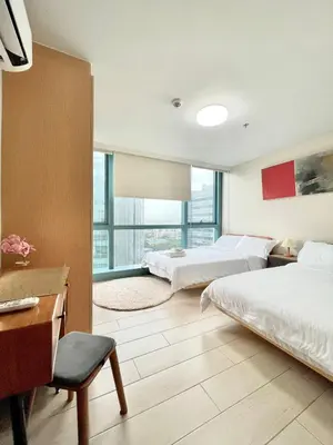 a hotel room with two beds and a desk at Spacious 2-BR unit in One Uptown Residences in Manila