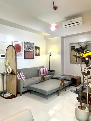 a living room with a couch and a table at Spacious 2-BR unit in One Uptown Residences in Manila