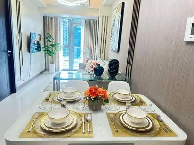 a dining room table with plates and dishes on it at Executive Stay with Balcony & Malls at Uptown BGC in Manila