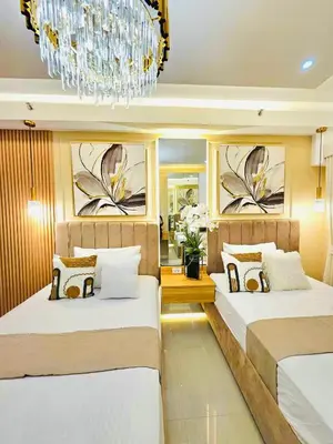 a bedroom with two beds and a chandelier at Jai Suite K&J Cozy Place Staycation in Manila