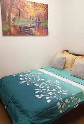 a bed in a room with a painting on the wall at Condo in Parañaque in Manila